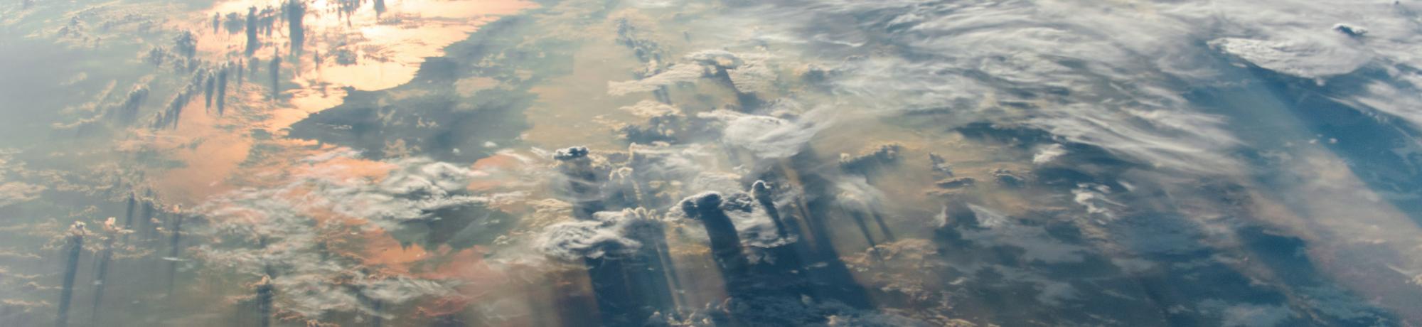 A view of the Earth from space, with clouds like mountains below.